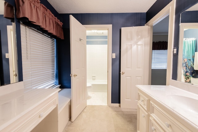 full bathroom featuring washtub / shower combination, vanity, a textured ceiling, and toilet