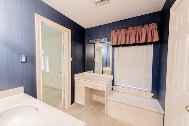 bathroom featuring a tub, vanity, and a textured ceiling