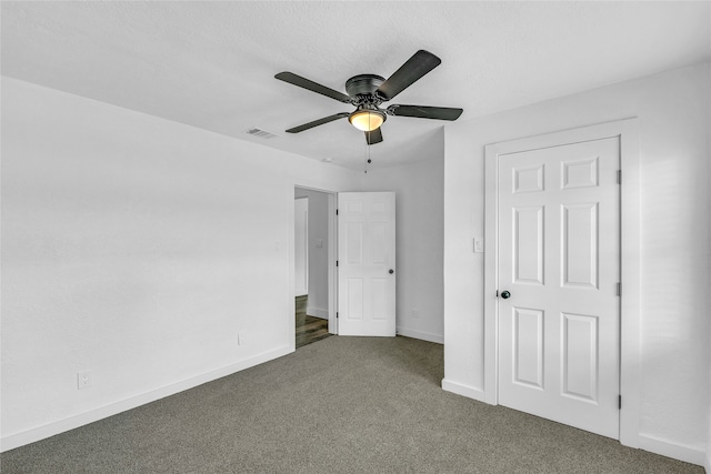 unfurnished bedroom with a textured ceiling, carpet floors, and ceiling fan