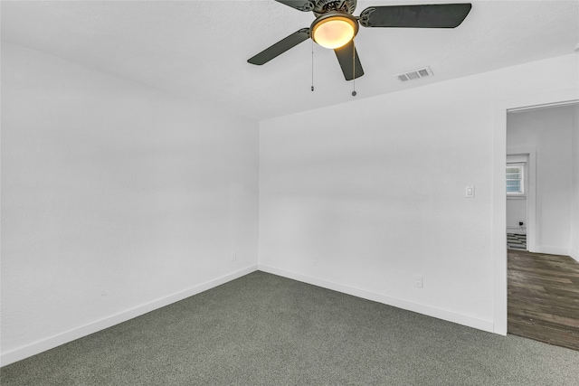 unfurnished room with dark carpet and ceiling fan