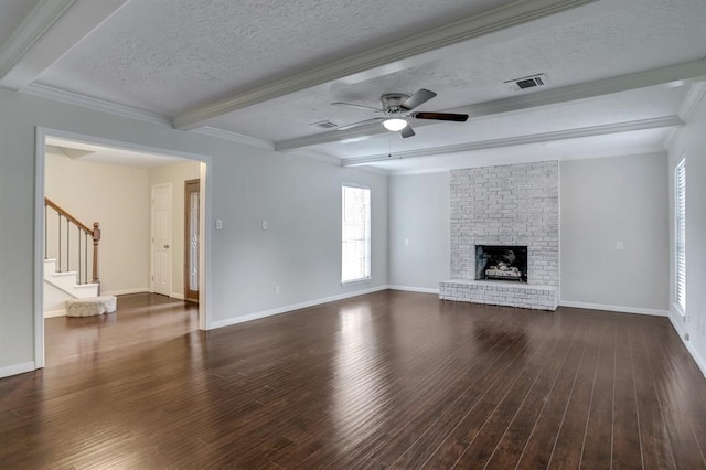 unfurnished living room featuring dark wood-type flooring, beamed ceiling, a textured ceiling, a fireplace, and ornamental molding