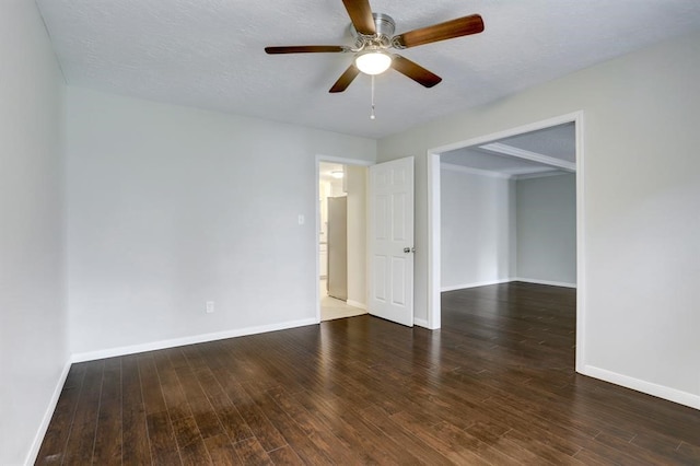 spare room with a textured ceiling, ceiling fan, and dark wood-type flooring