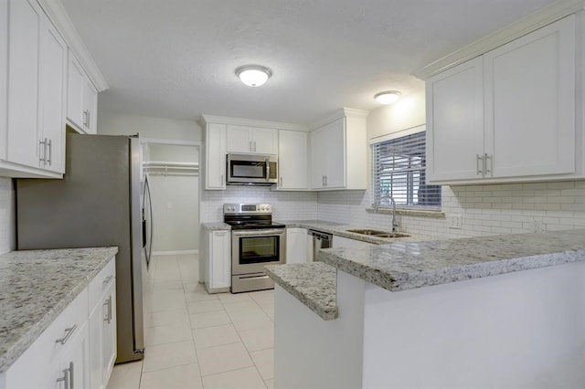 kitchen featuring light stone countertops, sink, backsplash, white cabinets, and appliances with stainless steel finishes