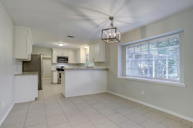 kitchen with white cabinetry, decorative light fixtures, a chandelier, backsplash, and stainless steel appliances