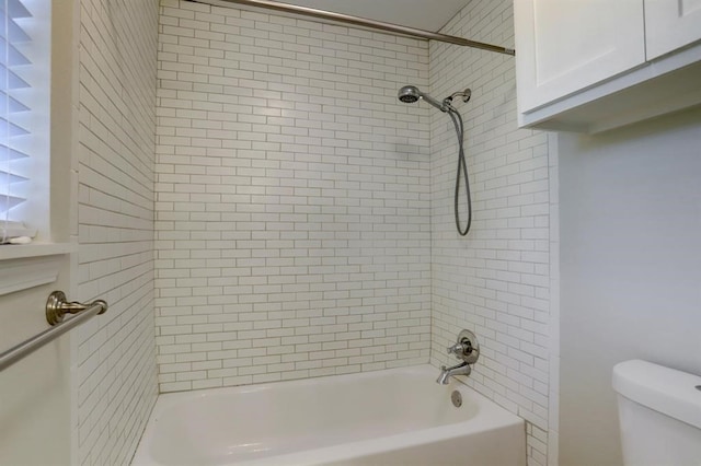 bathroom with toilet and tiled shower / bath combo