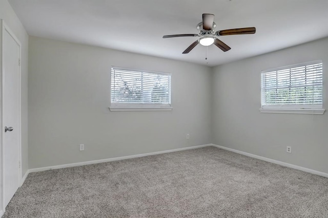 carpeted empty room featuring plenty of natural light and ceiling fan