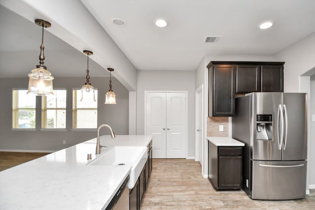 kitchen with light hardwood / wood-style flooring, sink, hanging light fixtures, appliances with stainless steel finishes, and dark brown cabinetry