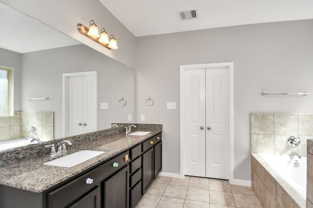 bathroom with vanity, tiled bath, and tile patterned floors