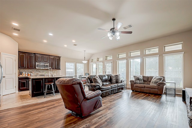 living room featuring ceiling fan, hardwood / wood-style floors, and lofted ceiling