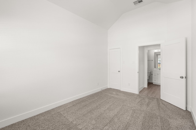 unfurnished bedroom featuring carpet flooring and high vaulted ceiling