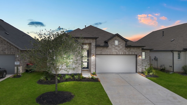 french country home featuring a garage and a lawn