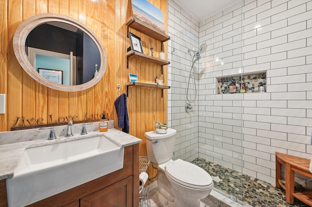 bathroom featuring vanity, toilet, and a tile shower