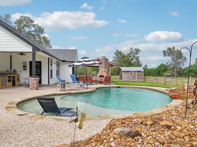 view of pool with a storage unit, a fireplace, and a patio