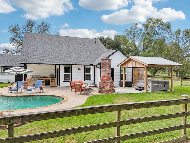 back of property featuring a swimming pool with hot tub, a patio, and an outdoor hangout area