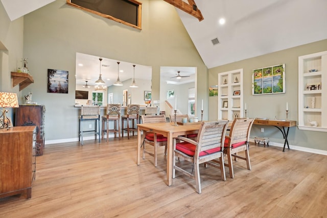 dining area featuring built in shelves, ceiling fan, high vaulted ceiling, light hardwood / wood-style flooring, and beamed ceiling