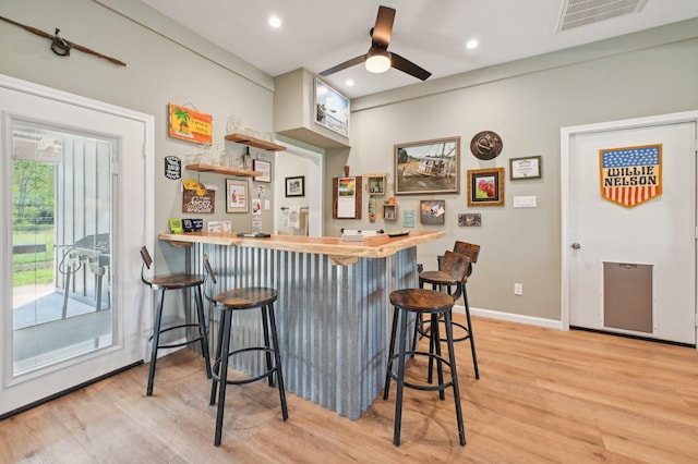 bar with light wood-type flooring, butcher block countertops, a wealth of natural light, and ceiling fan