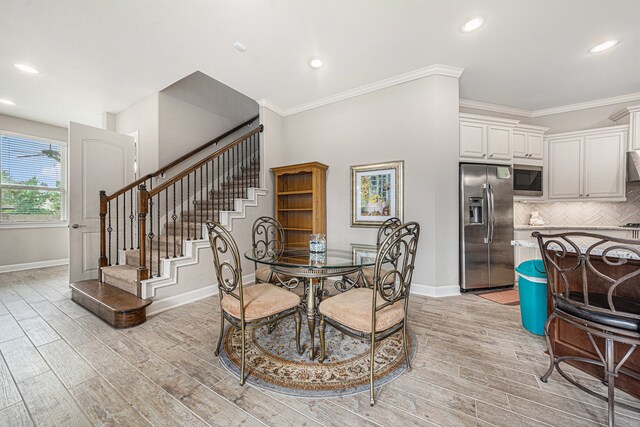 dining room with light hardwood / wood-style flooring and ornamental molding