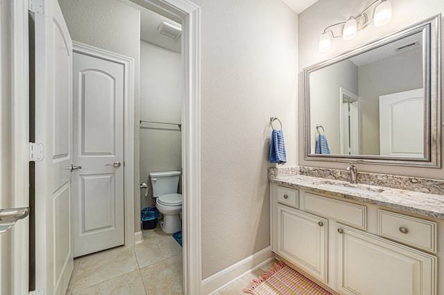 bathroom with tile patterned flooring, vanity, and toilet