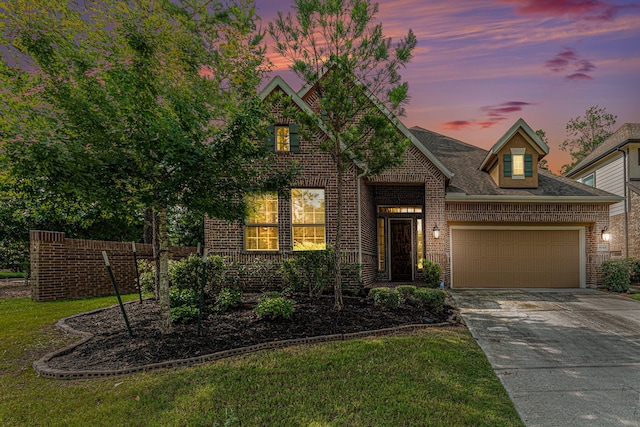 view of front of house featuring a garage and a lawn