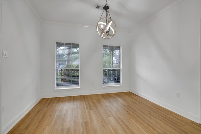 empty room with light hardwood / wood-style floors, crown molding, and a chandelier