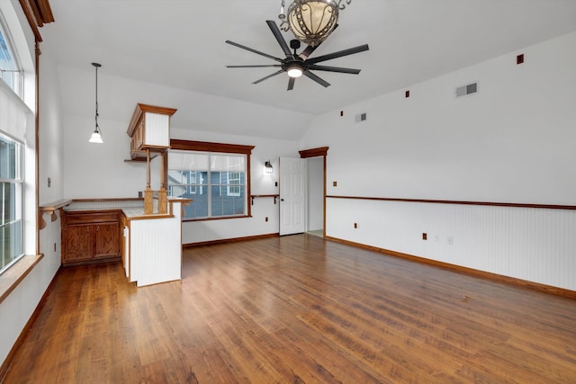 unfurnished living room featuring dark wood-type flooring, vaulted ceiling, and a healthy amount of sunlight