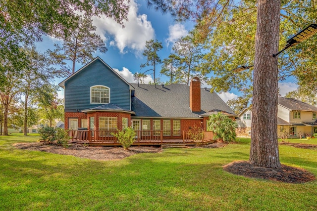 rear view of property featuring a lawn and a wooden deck