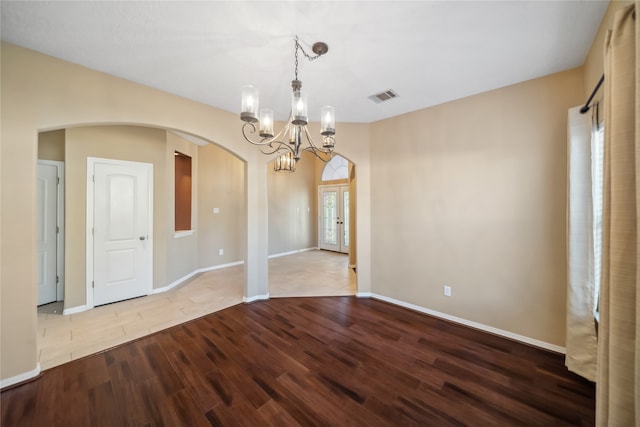 empty room with an inviting chandelier and light wood-type flooring