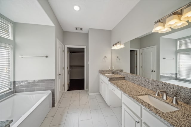 bathroom featuring vanity and a bath