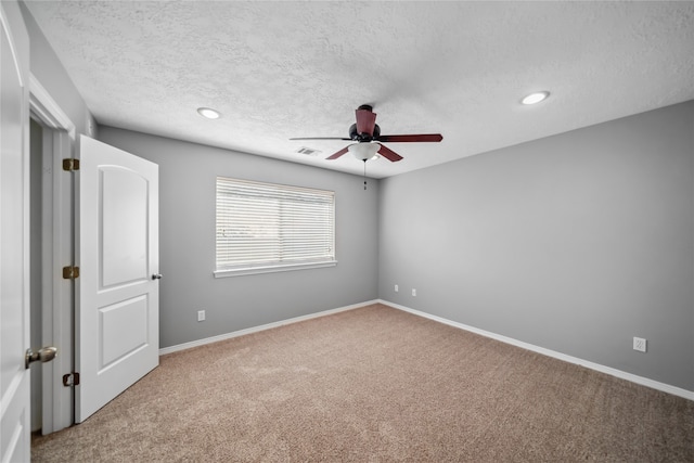 carpeted spare room with ceiling fan and a textured ceiling