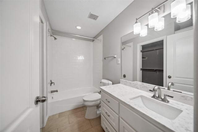 full bathroom featuring tile patterned flooring, vanity, tiled shower / bath combo, and toilet