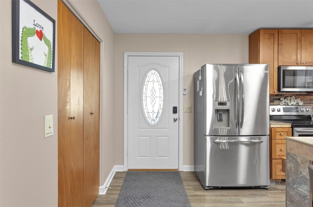 161 Cayman St, Point Blank, TX 77364 - kitchen with appliances with stainless steel finishes, brown cabinets, light wood-style flooring, and backsplash