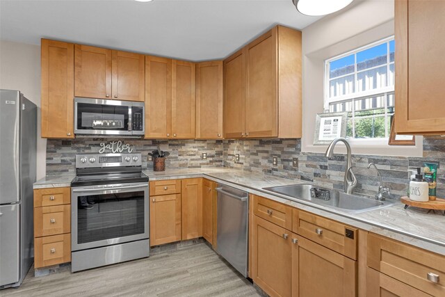 161 Cayman St, Point Blank, TX 77364 - kitchen featuring appliances with stainless steel finishes, a sink, light wood-style flooring, and light countertops