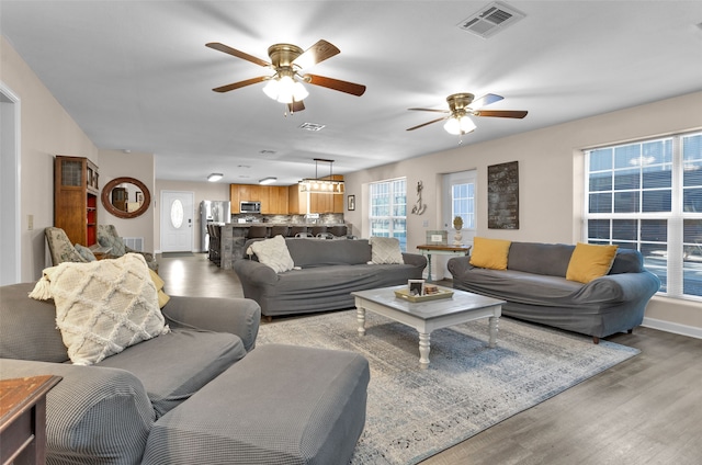 living room with wood-type flooring and ceiling fan