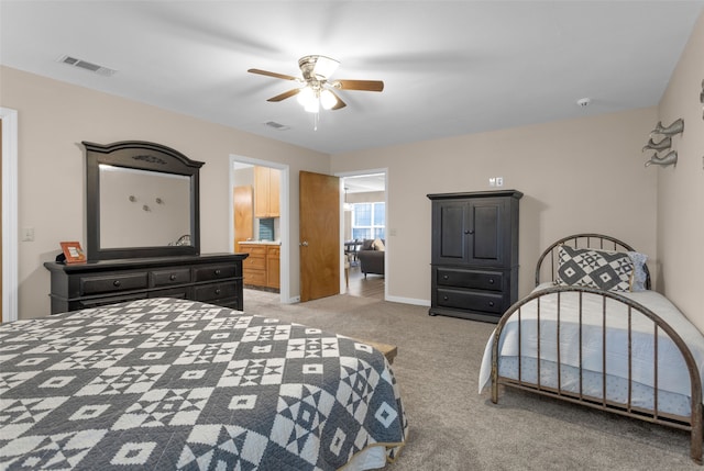 bedroom featuring ceiling fan, ensuite bathroom, and light carpet