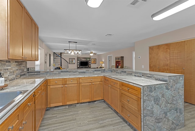 kitchen featuring kitchen peninsula, ceiling fan, and light hardwood / wood-style flooring