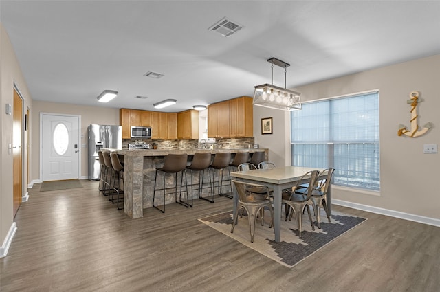 dining room with a healthy amount of sunlight and dark hardwood / wood-style flooring