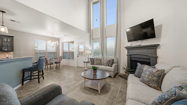 living room with a notable chandelier, a high ceiling, and tile patterned floors