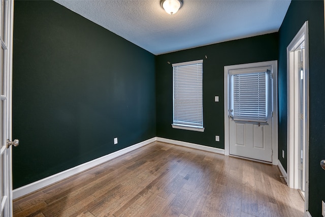 empty room featuring a textured ceiling and light hardwood / wood-style flooring