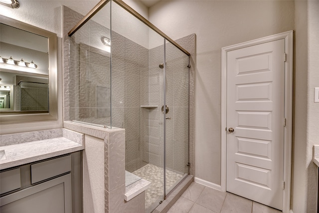 bathroom featuring tile patterned flooring, vanity, and a shower with door