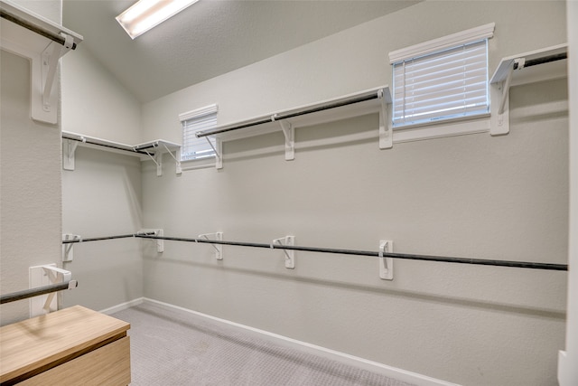 spacious closet featuring carpet flooring and lofted ceiling