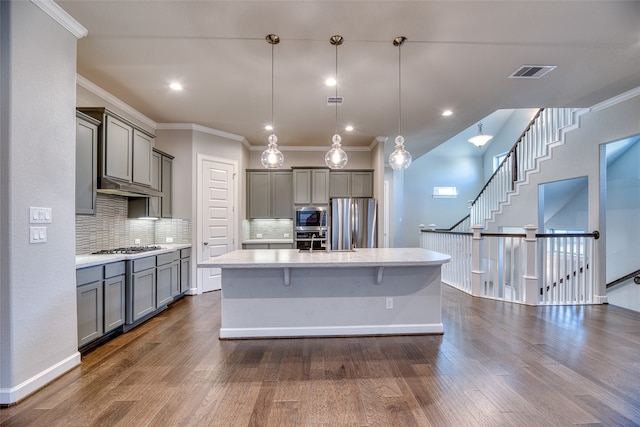 kitchen with stainless steel appliances, hanging light fixtures, and dark hardwood / wood-style floors