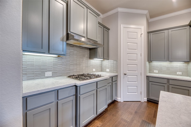 kitchen featuring tasteful backsplash, ornamental molding, dark hardwood / wood-style floors, and stainless steel gas cooktop