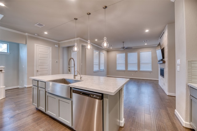 kitchen featuring sink, dishwasher, an island with sink, pendant lighting, and hardwood / wood-style flooring