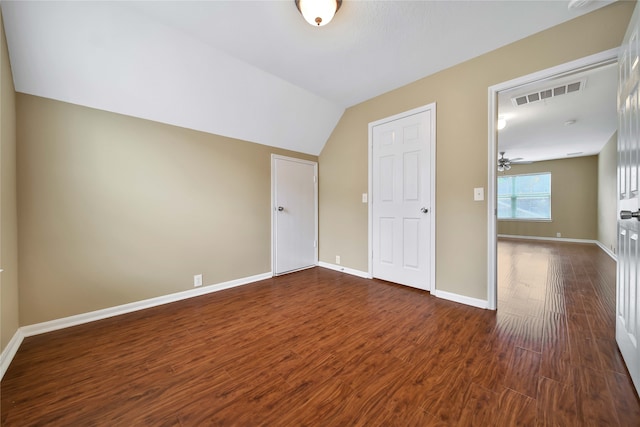 interior space featuring lofted ceiling, ceiling fan, and dark wood-type flooring