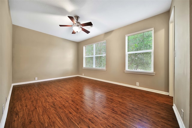 unfurnished room with ceiling fan, dark wood-type flooring, and a healthy amount of sunlight