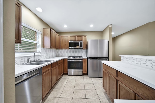 kitchen featuring sink, appliances with stainless steel finishes, light tile patterned floors, tasteful backsplash, and light stone countertops