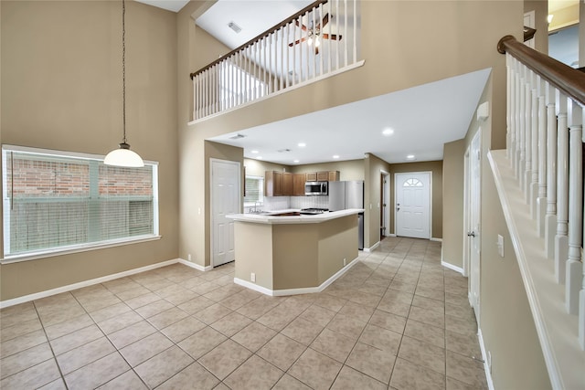 kitchen featuring decorative backsplash, light tile patterned flooring, and a high ceiling