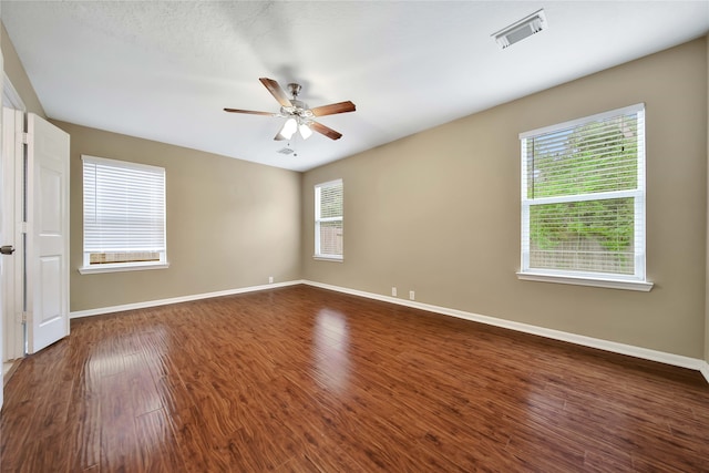 empty room with dark hardwood / wood-style floors and ceiling fan