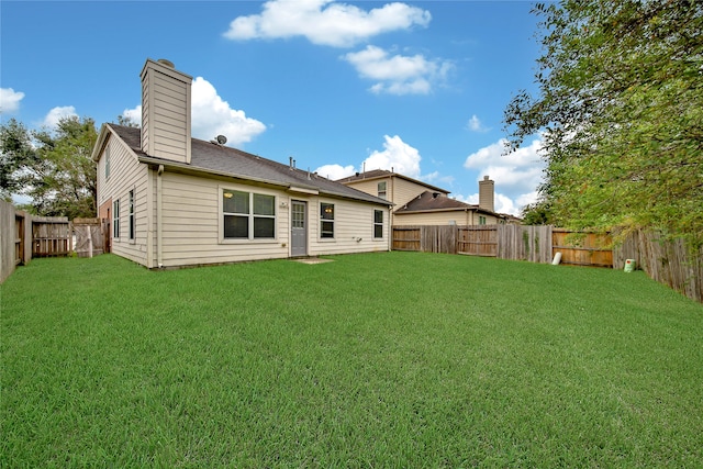 rear view of house with a yard