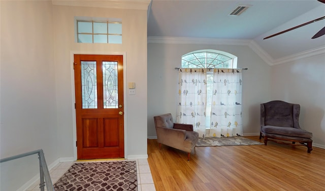 entrance foyer with light hardwood / wood-style flooring, vaulted ceiling, ornamental molding, and ceiling fan